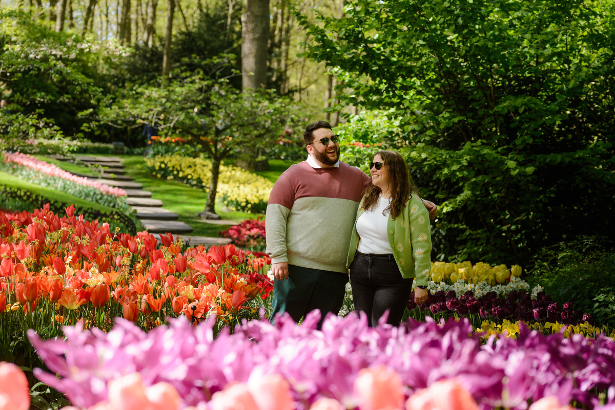Newly engaged couple celebrating among spring flowers.