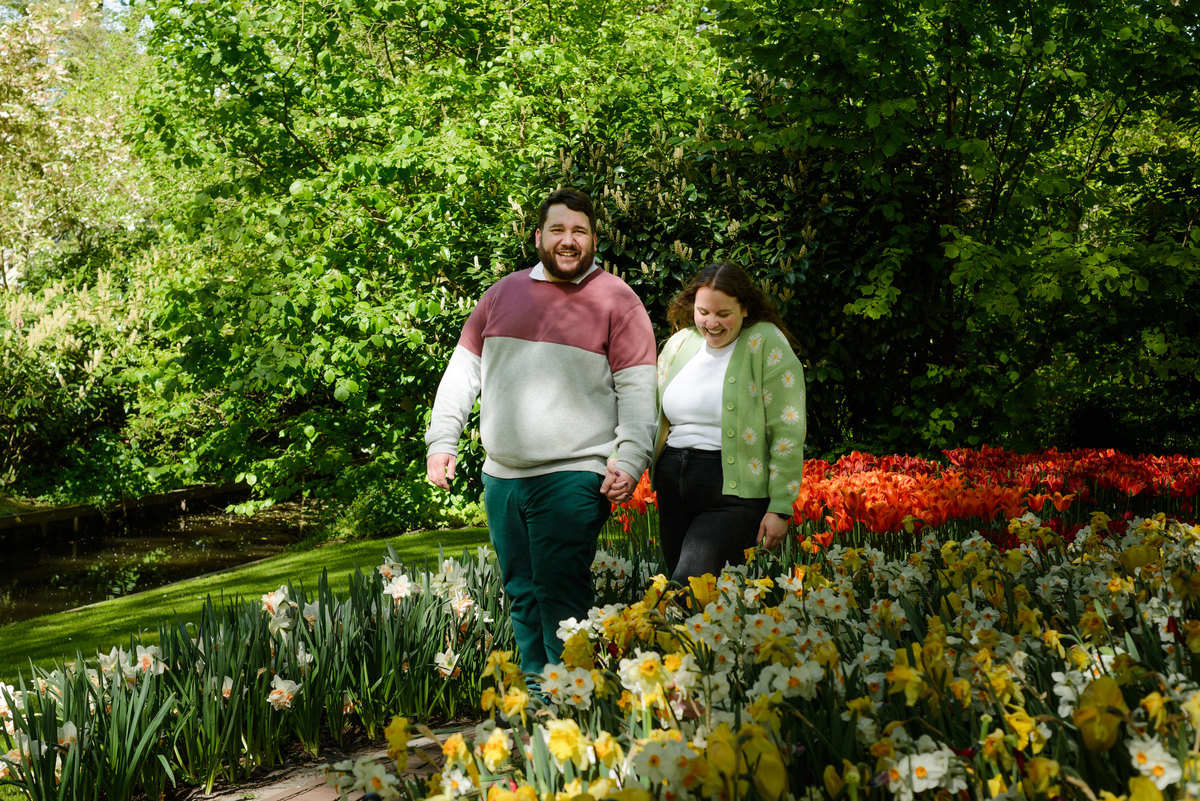 Newly engaged couple celebrating among spring flowers.