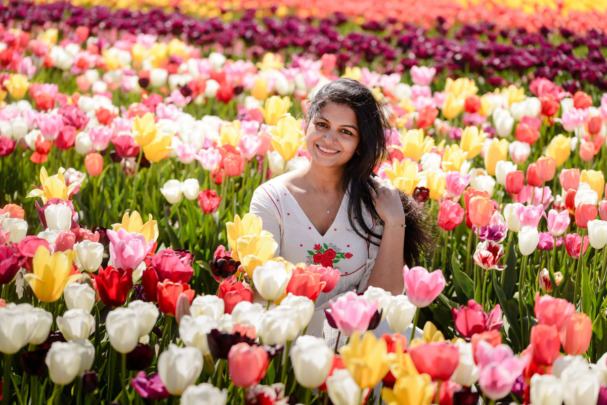 Natural portrait of a woman walking through blooming tulip gardens at The Tulip Barn.
