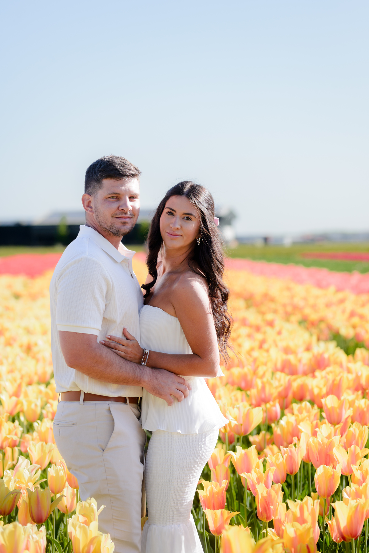 Newly engaged couple celebrating among blooming tulips.