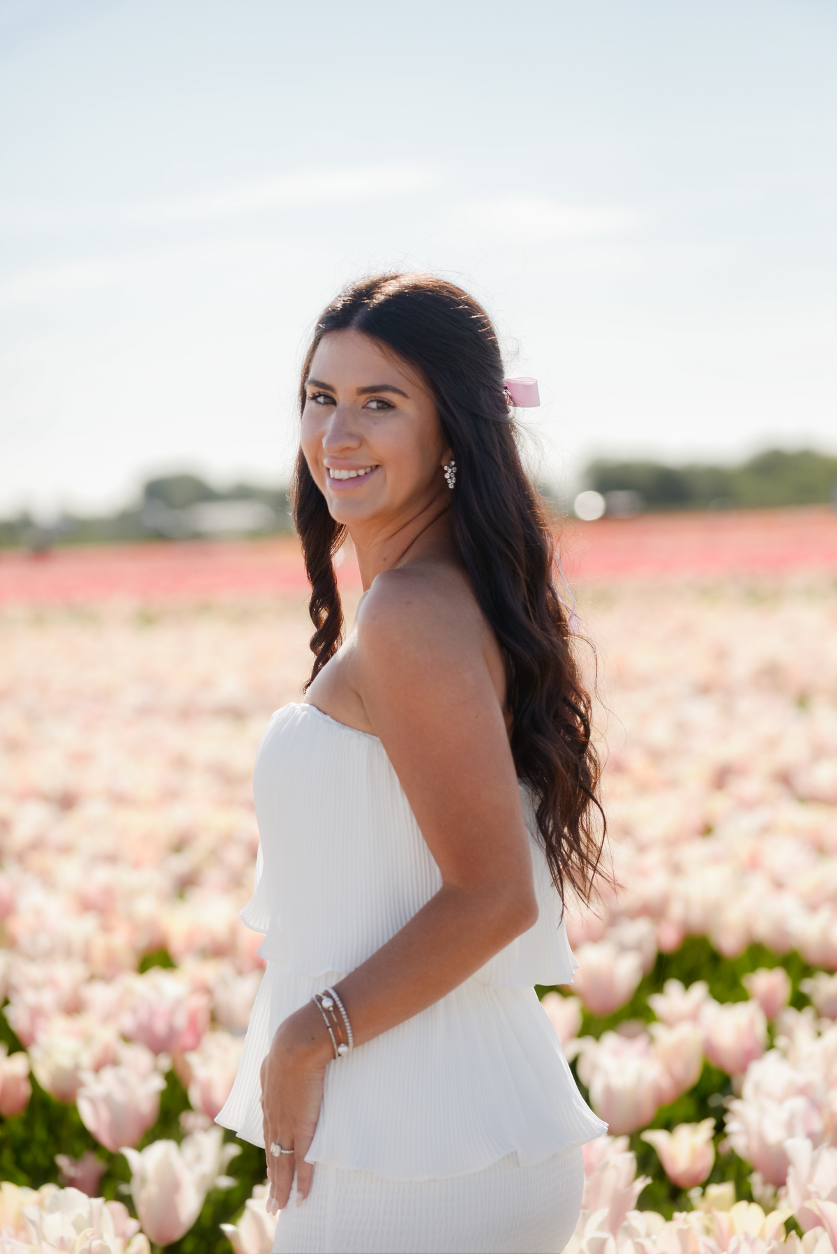 Portrait of a woman surrounded by pink flowers during tulip season in the Netherlands.