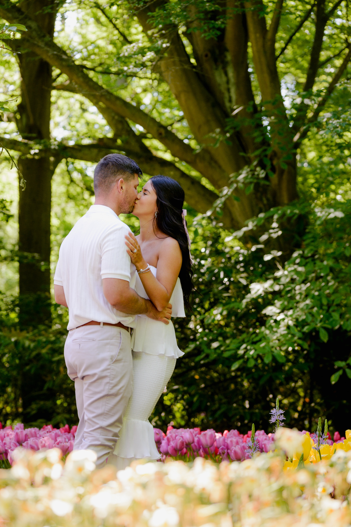 Joyful engagement portraits surrounded by spring flowers at Keukenhof.