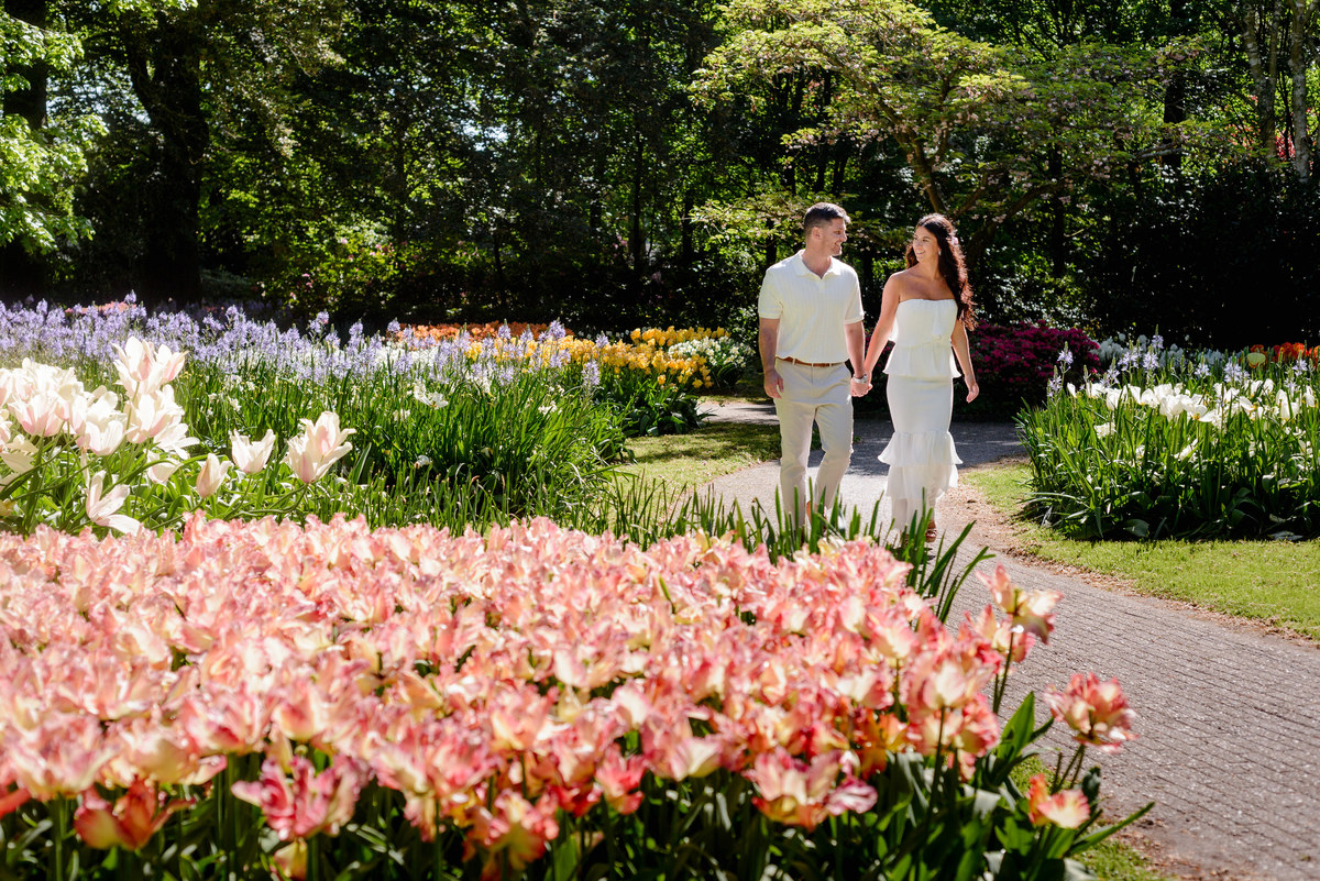 Couple walking together through Keukenhof Gardens after their engagement.