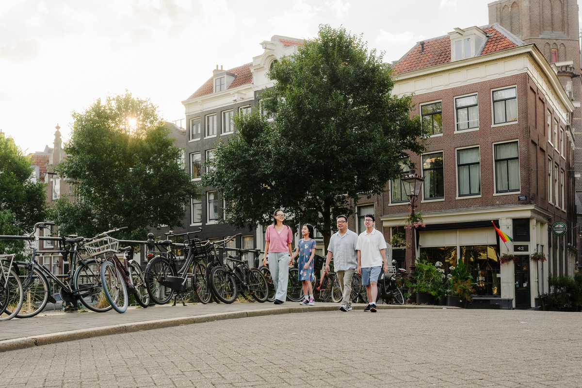 Family walking together beside Amsterdam's historic canals.