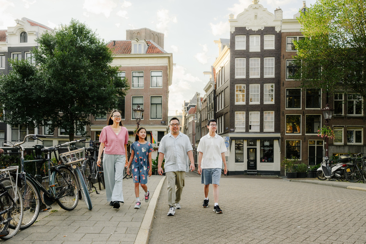 Family walking together beside Amsterdam's historic canals.