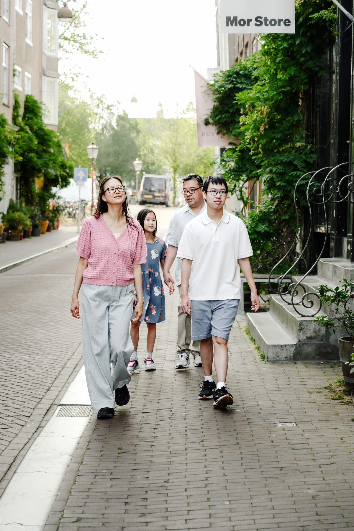 Family enjoying a quiet morning walk through Amsterdam's Canal Belt.