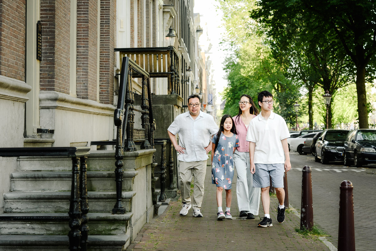 Family walking together beside Amsterdam's historic canals.