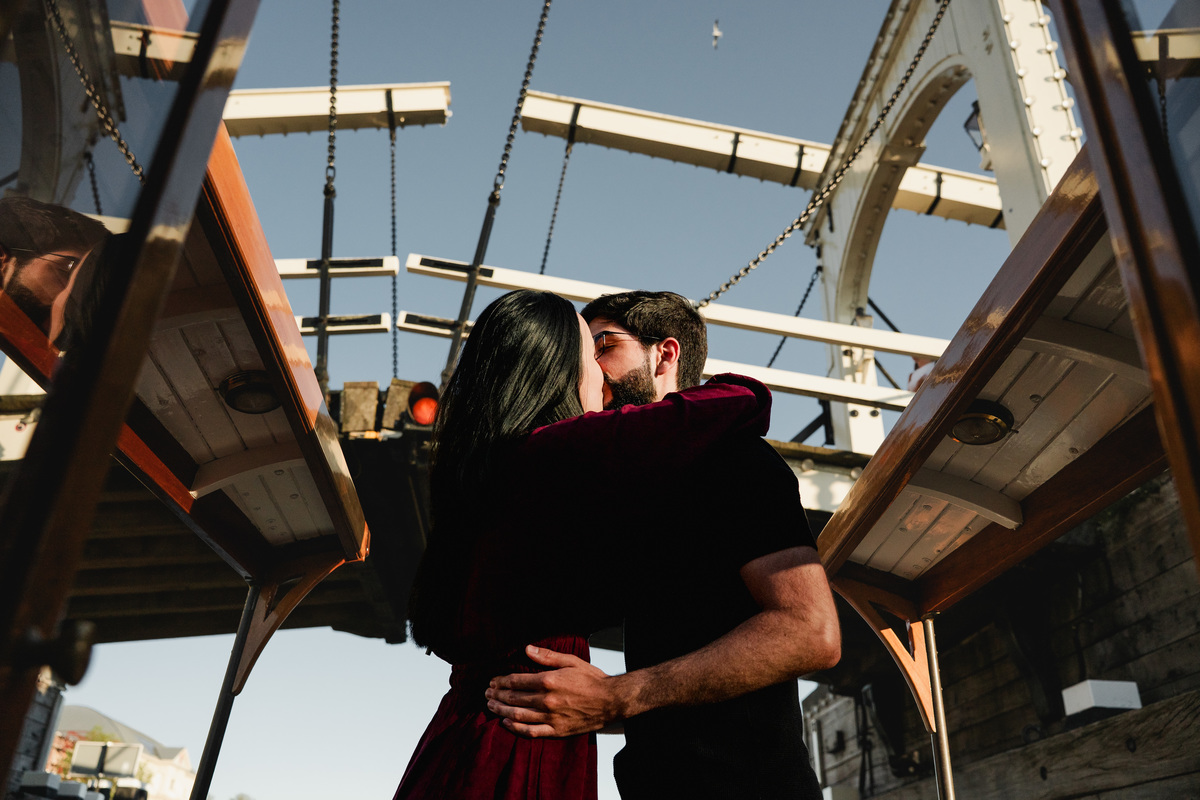 Newly engaged couple kissing under the Skinny bridge / Magere brug