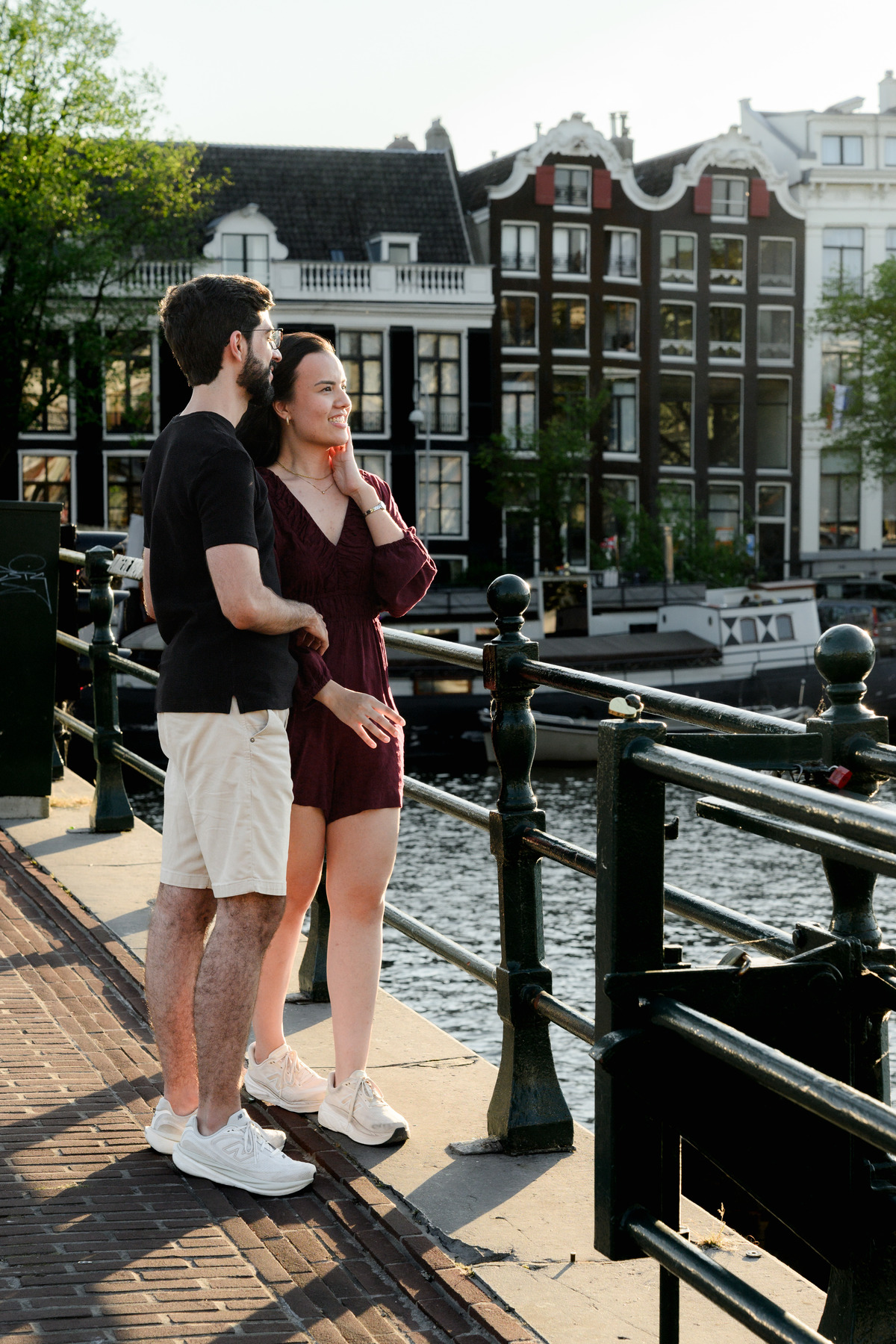 Couple walking through Amsterdam after their canal boat proposal.