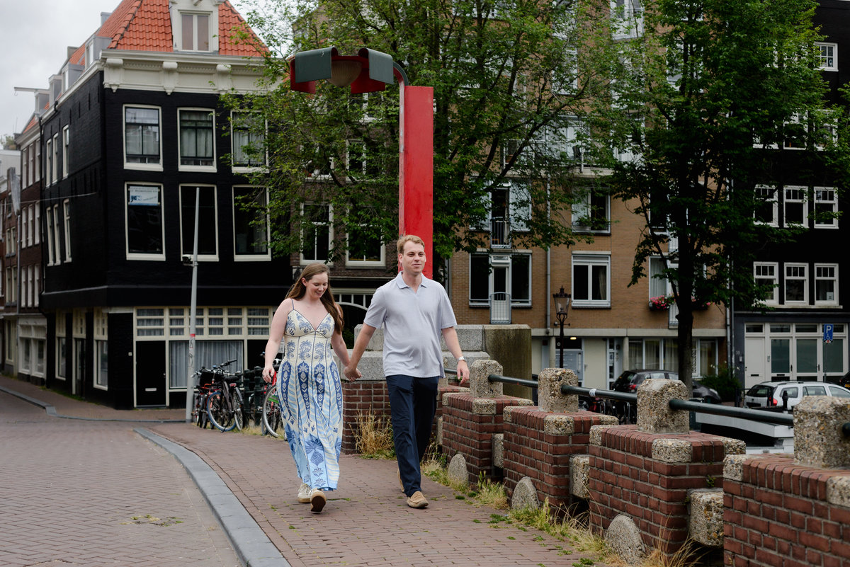 Couple walking across Keizerbrug before their morning proposal in Amsterdam