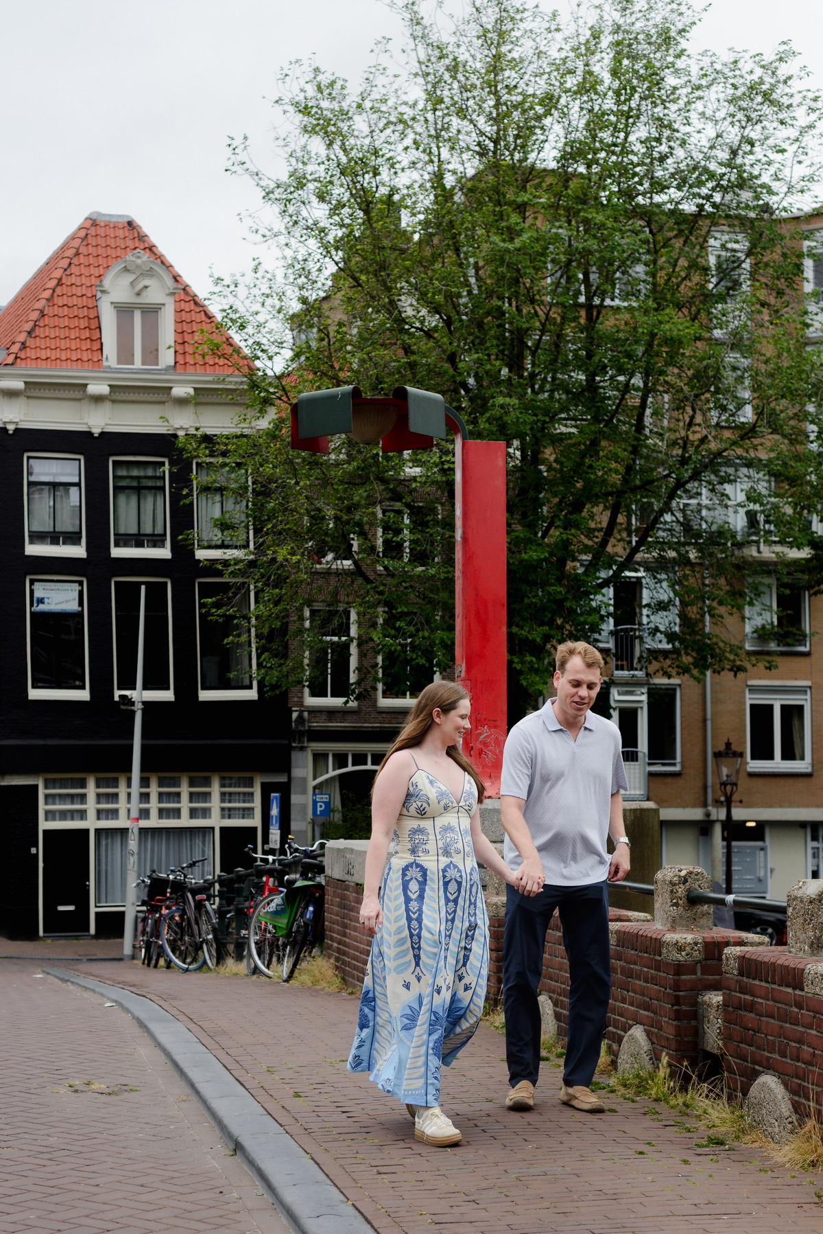 Couple walking across Keizerbrug before their morning proposal in Amsterdam