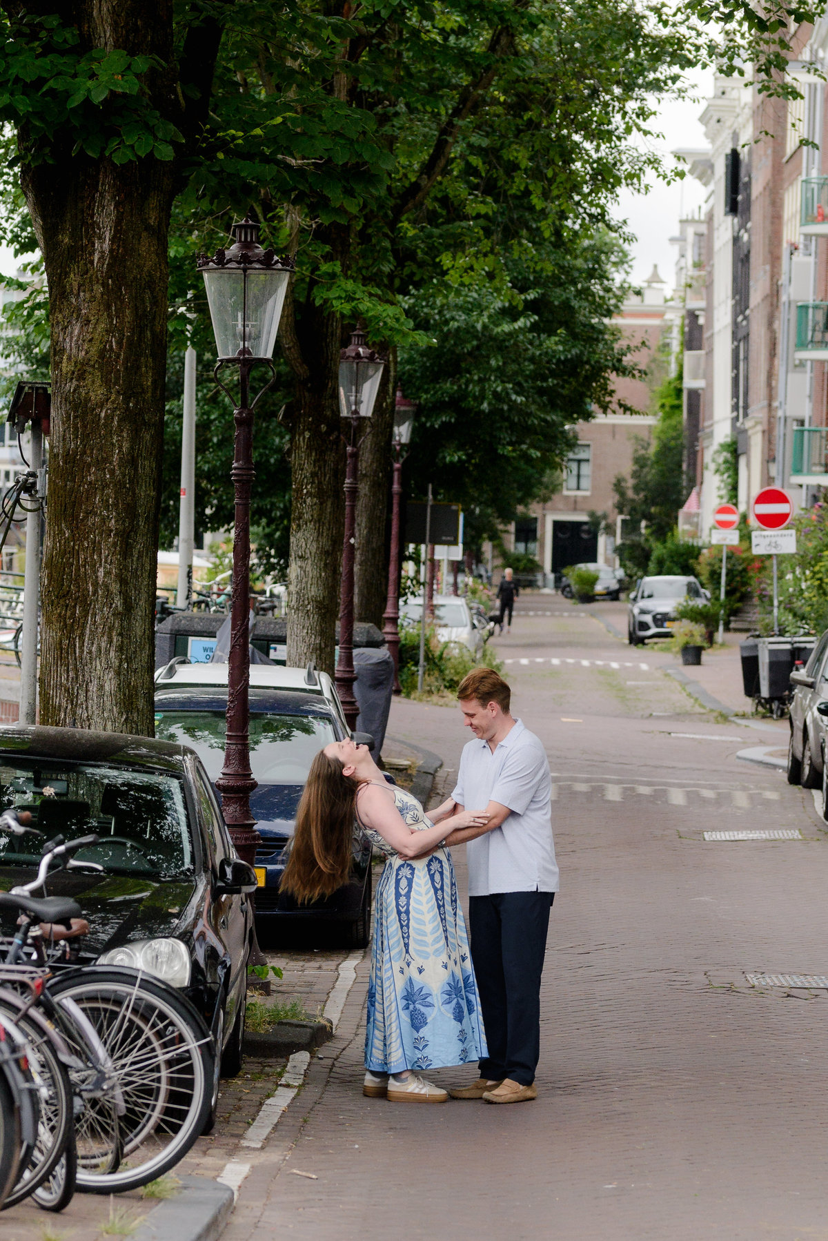 Newly engaged couple walking beside Oudeschans in Amsterdam
