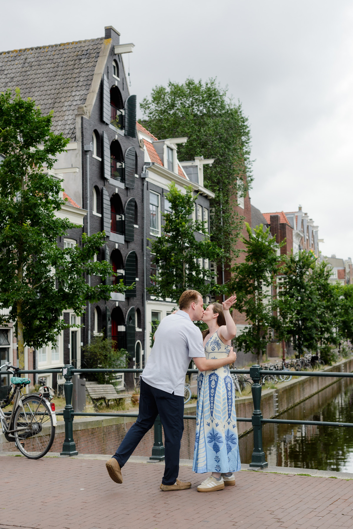 Newly engaged couple walking beside Oudeschans in Amsterdam