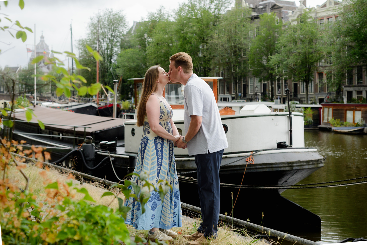 Newly engaged couple photographed near boats in central Amsterdam