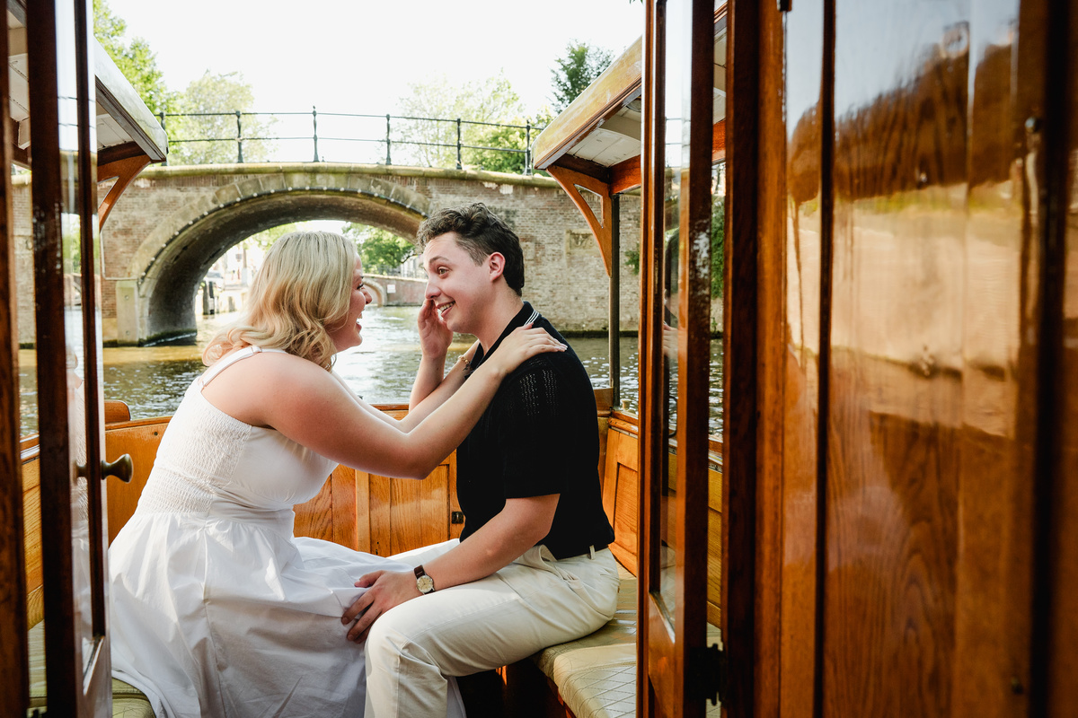 Newly engaged couple embracing beneath Amsterdam’s Seven Bridges