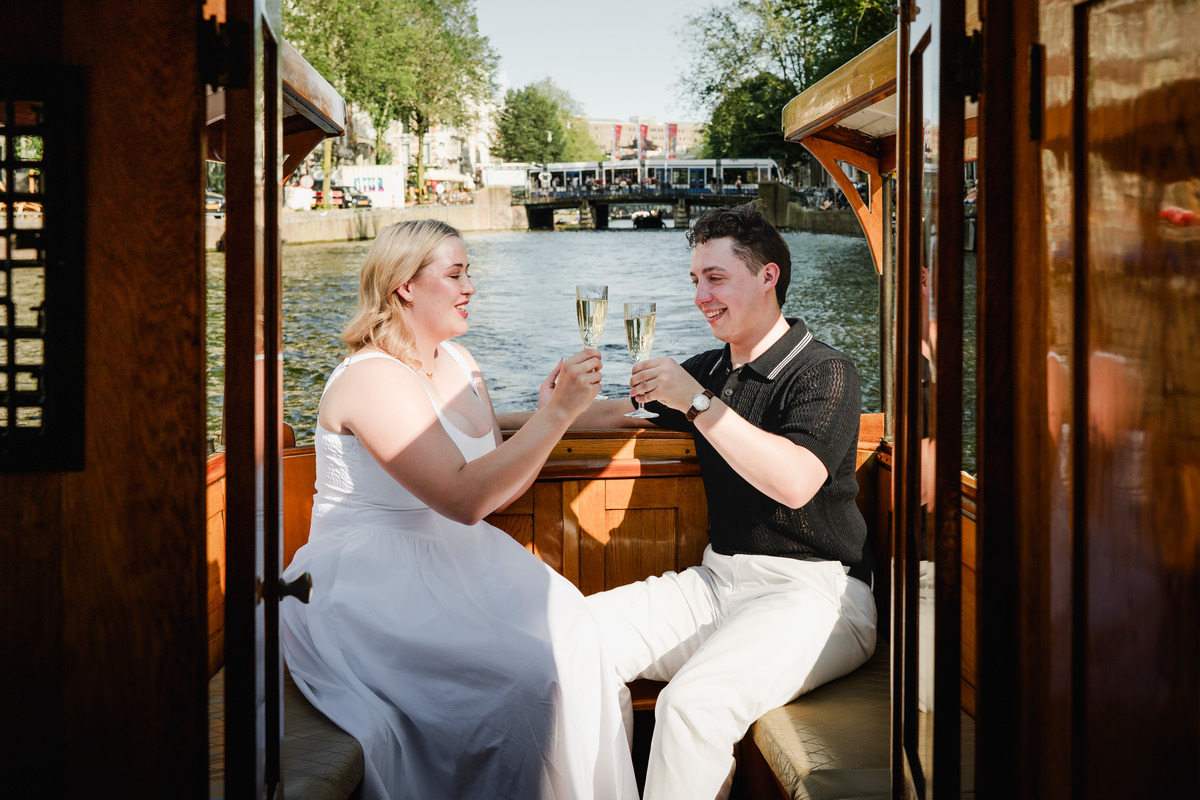 Newly engaged couple embracing beneath Amsterdam’s Seven Bridges