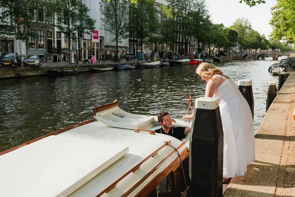 Couple boarding a historic wooden boat for a private Amsterdam canal cruise