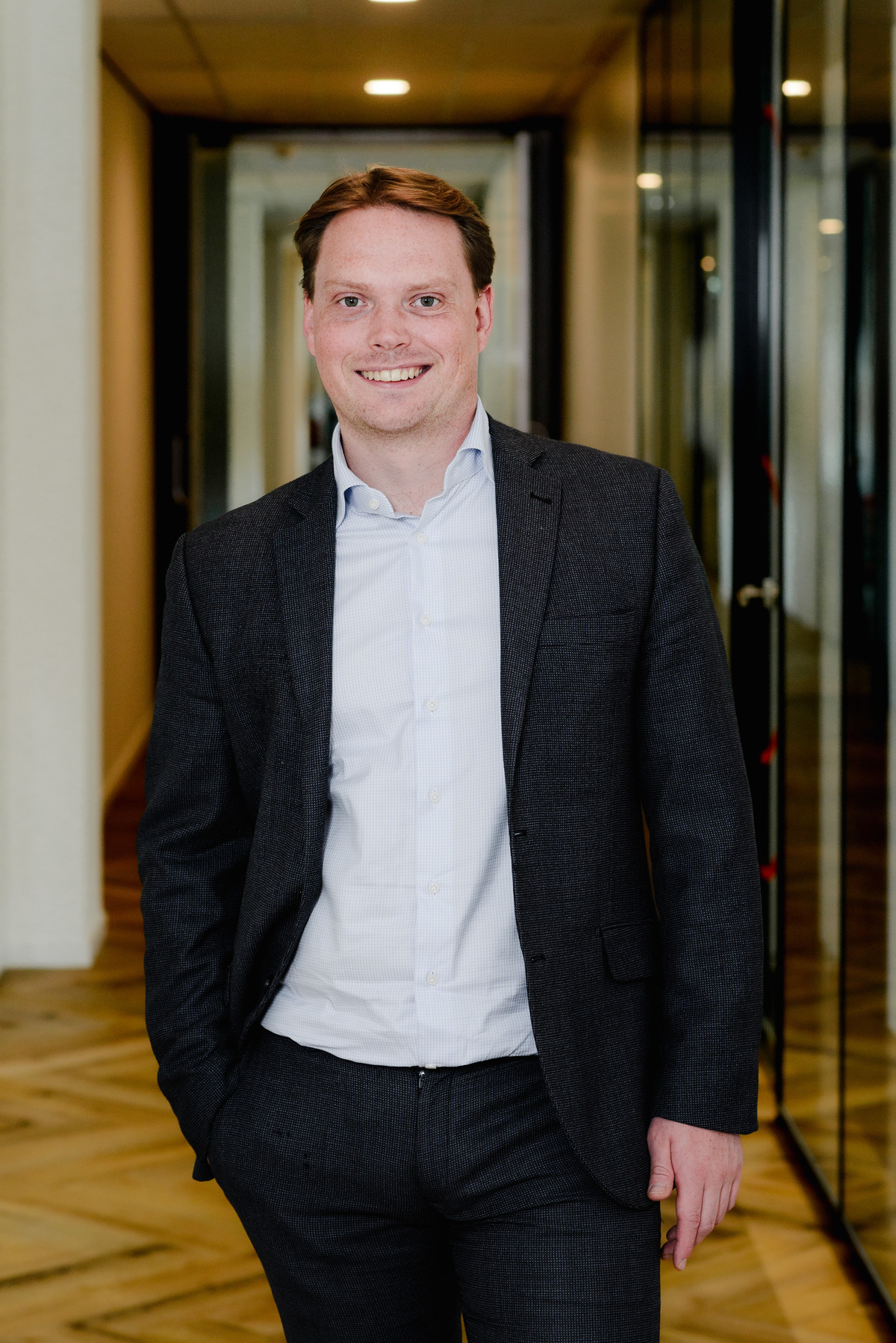 Professional corporate portrait of a team member standing in a modern Amsterdam office