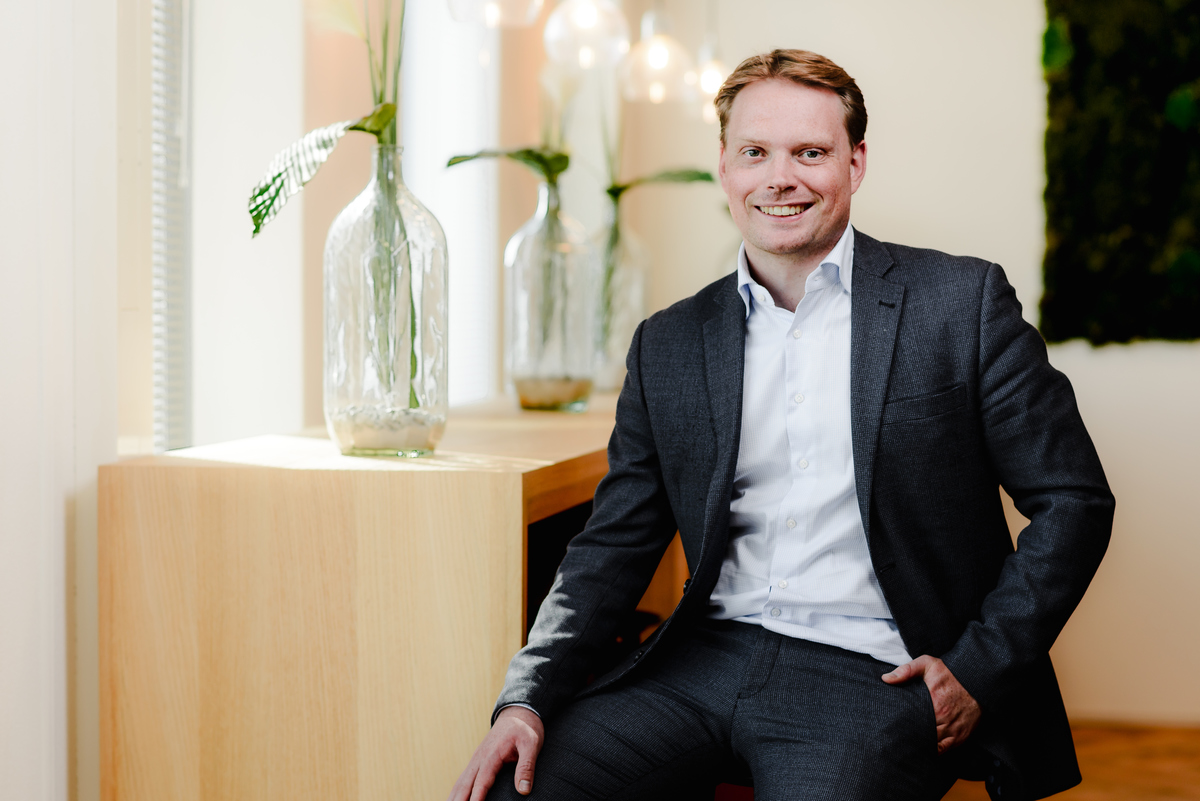 Seated corporate portrait photographed in a modern office environment in Amsterdam