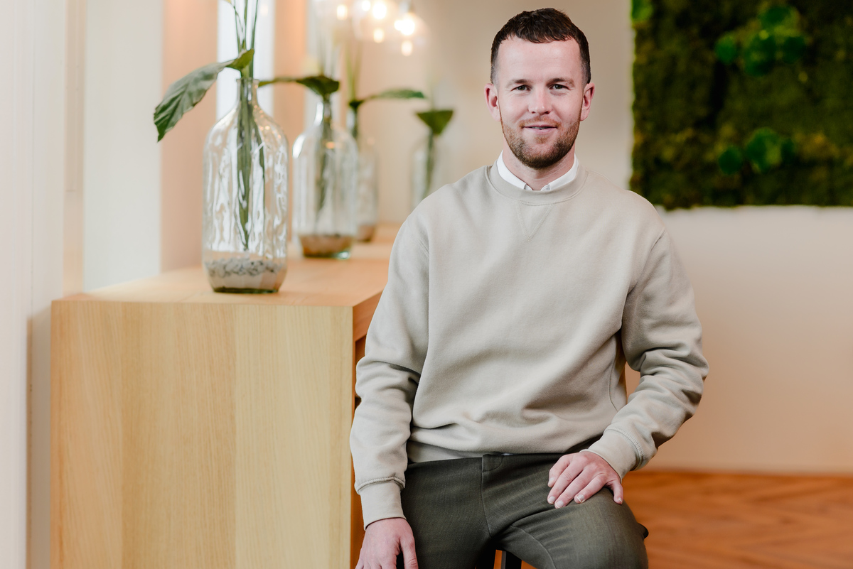 Natural corporate headshot of a team member photographed inside an Amsterdam office