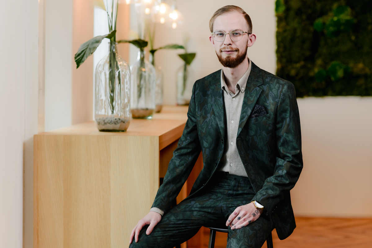 Environmental business portrait of a professional seated in a contemporary Amsterdam workplace