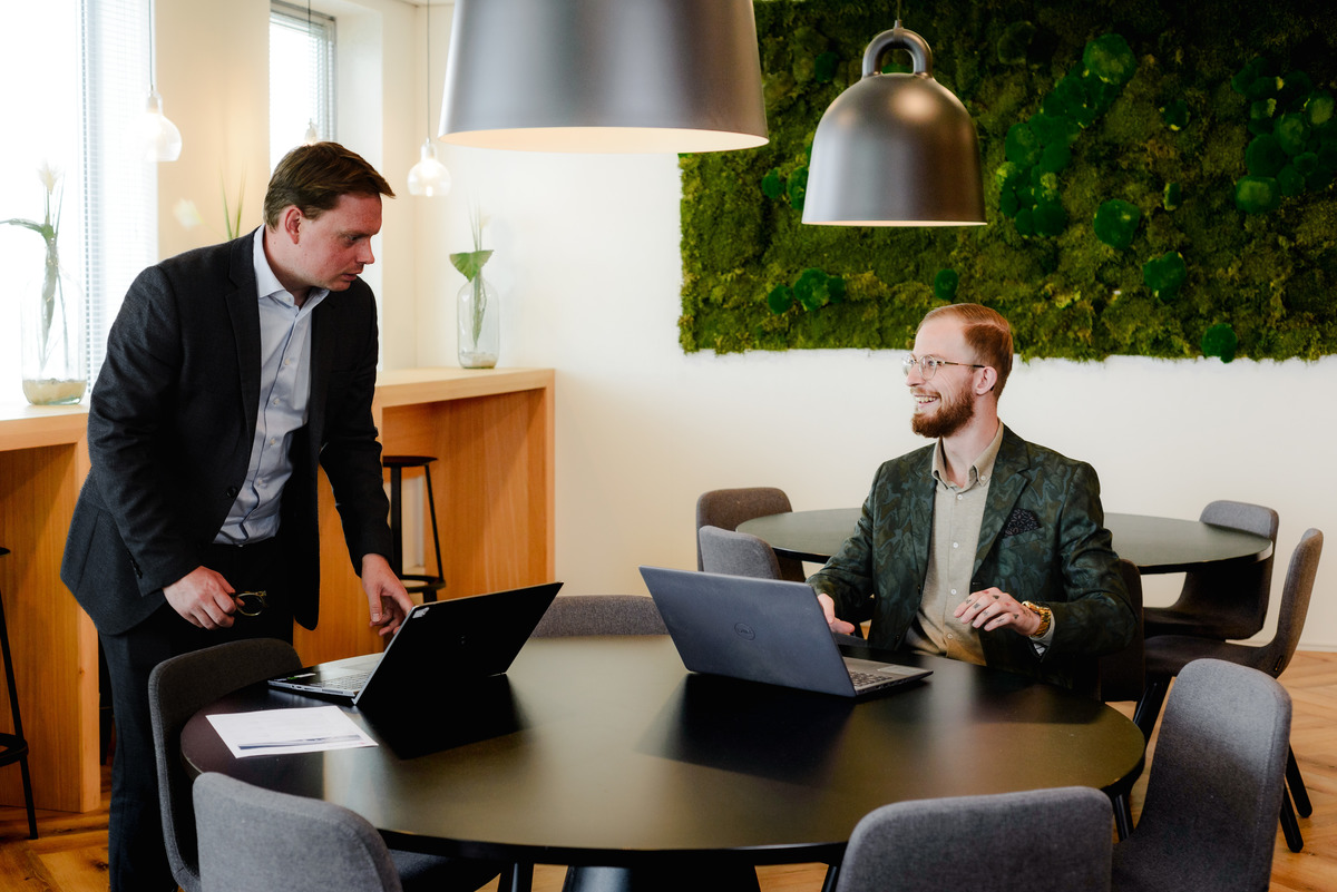 Natural team photography showing colleagues discussing work together in their Amsterdam office