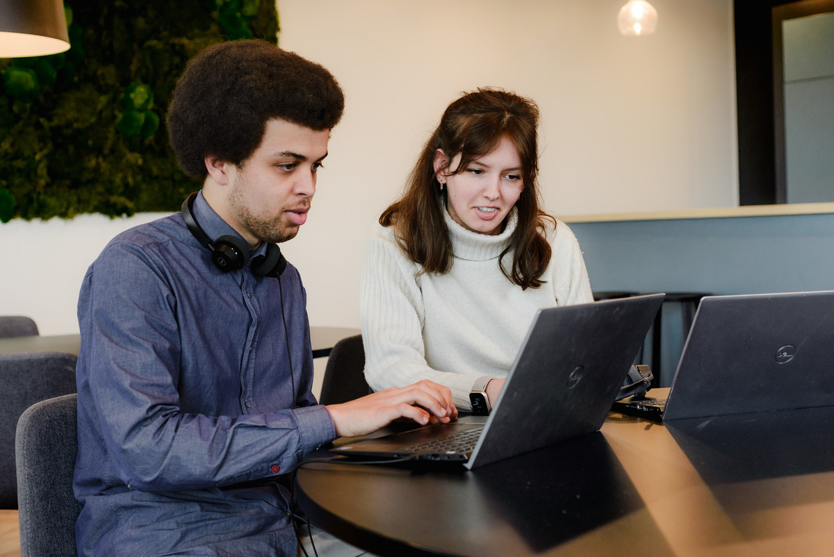 Two colleagues working together during a natural office photography session in Amsterdam