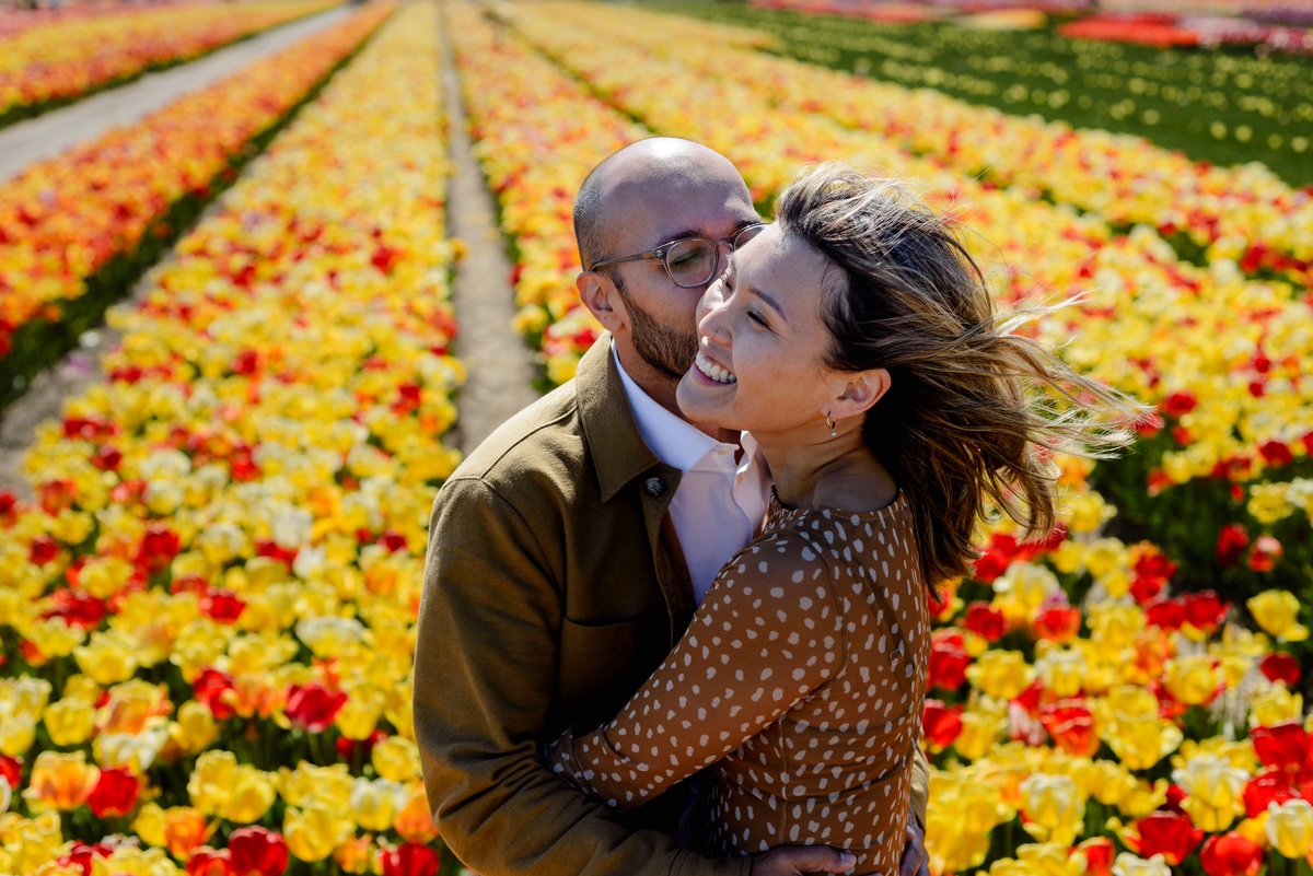 Engagement portraits among red, yellow and pink tulips