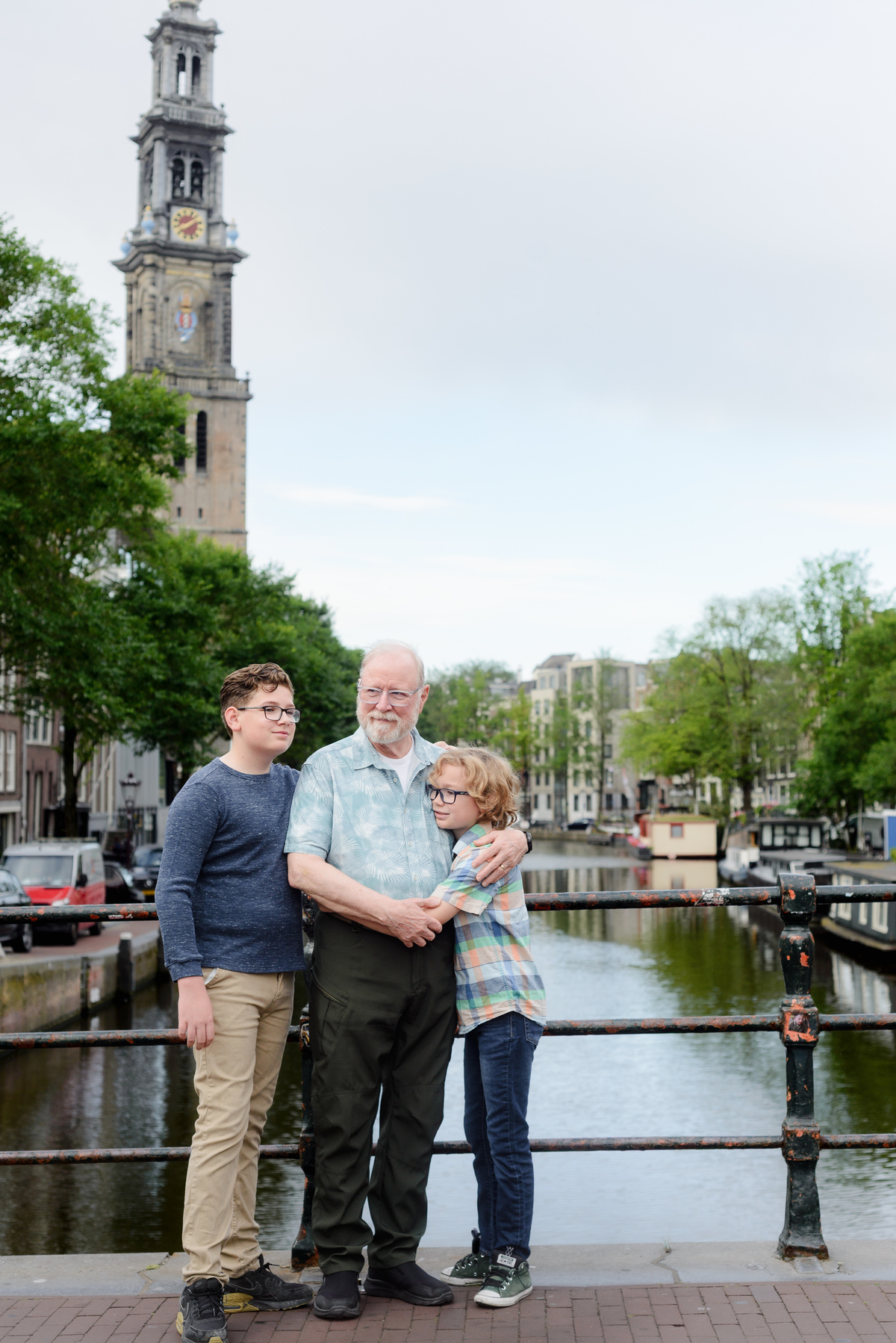 Grandfather and grandkids photographed together beside an Amsterdam canal house