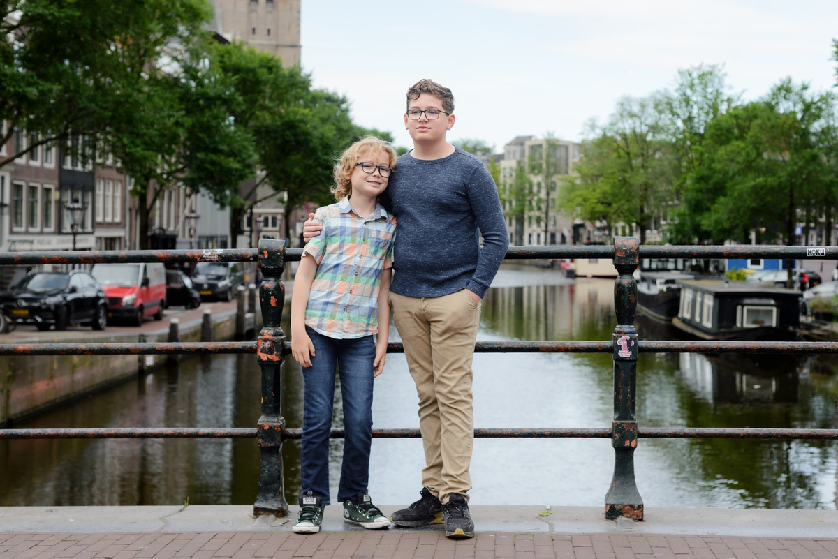 Kids photograph talking during a photo session with a canal view in the background. 