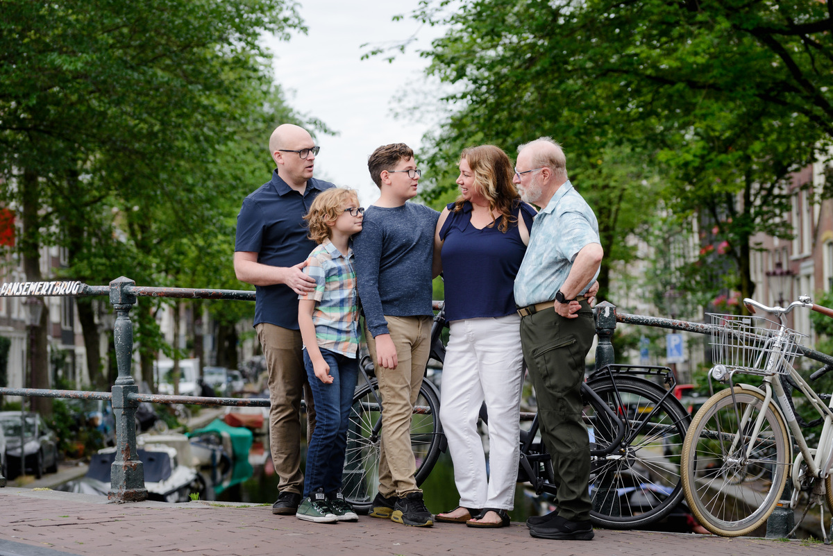Family portrait beside bicycles on a quiet Amsterdam street