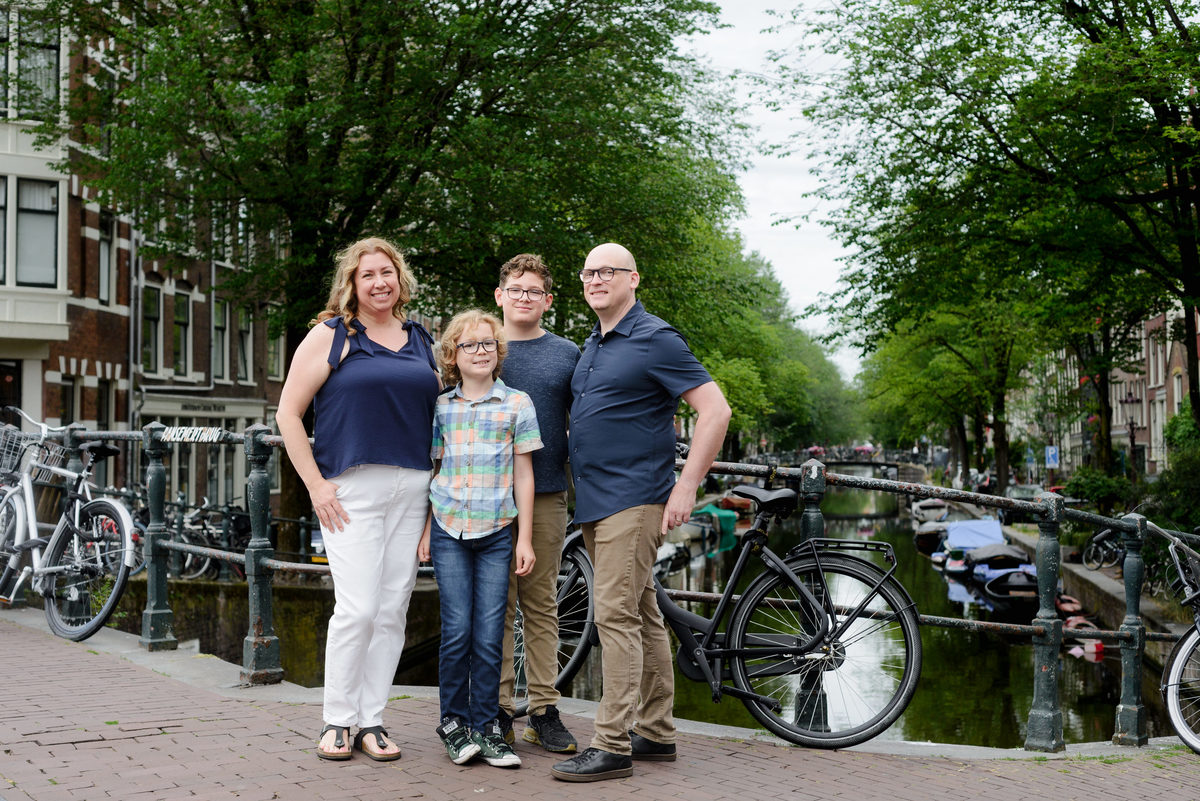 Family portrait beside bicycles on a quiet Amsterdam street