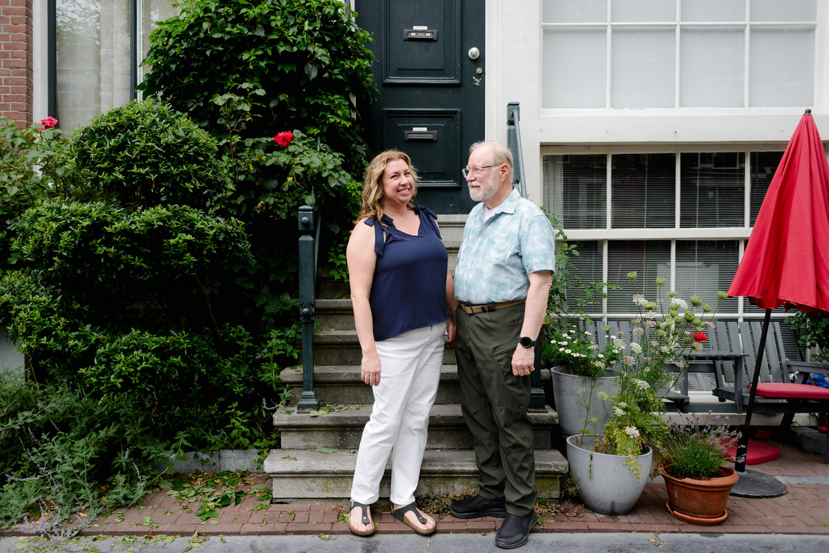 Father and adult daughter standing in front of a canal house in the Jordaan area in Amsterdam during a photo session 