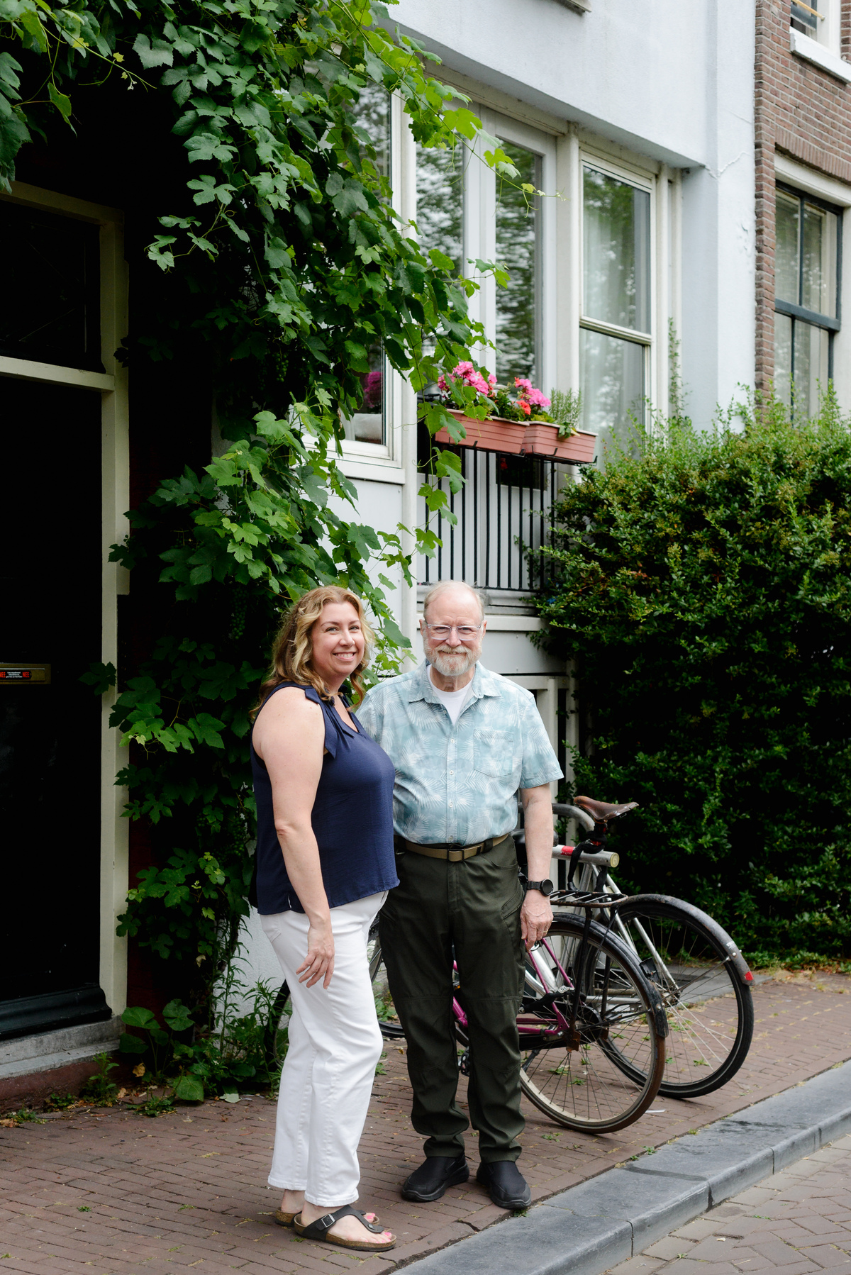 Father and adult daughter standing in front of a canal house in the Jordaan area in Amsterdam during a photo session 