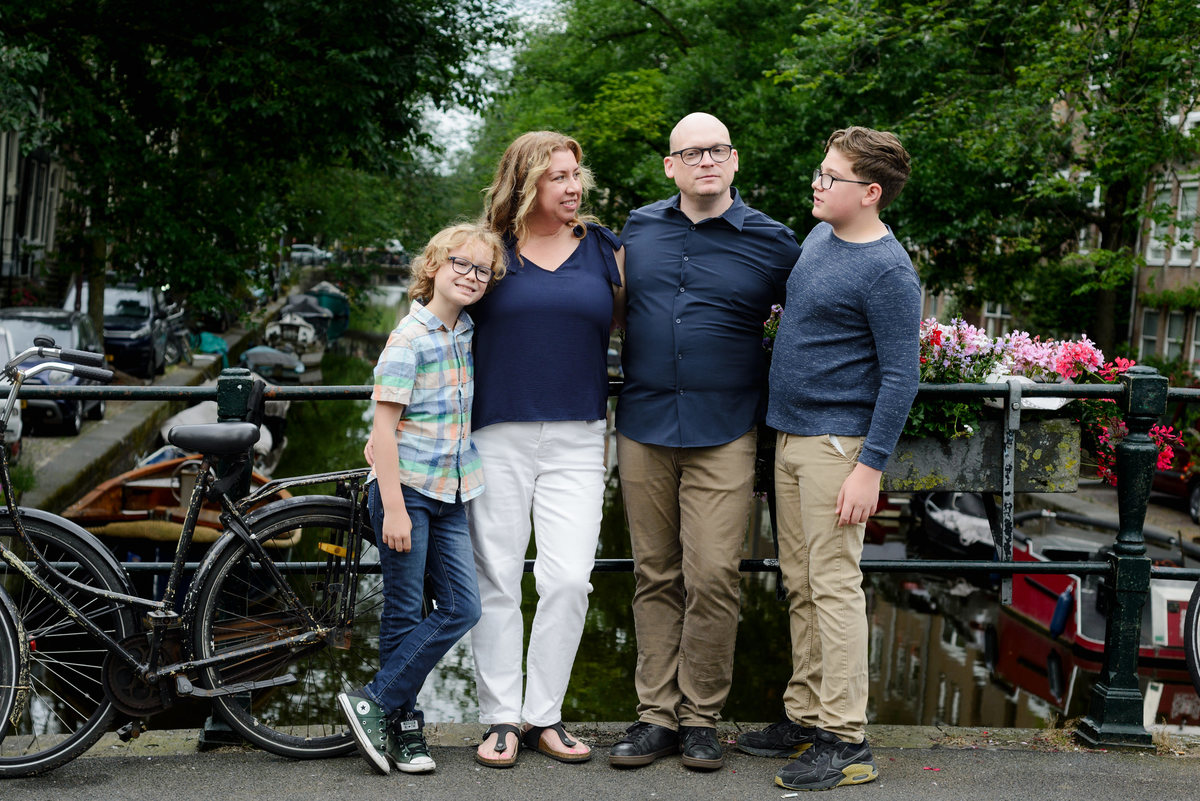 Family portrait beside bicycles on a quiet Amsterdam street