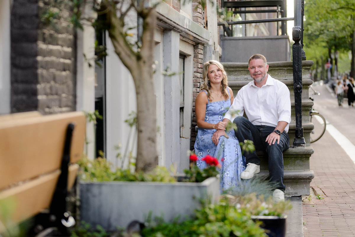 Couple sitting on the steps of a traditional Amsterdam house