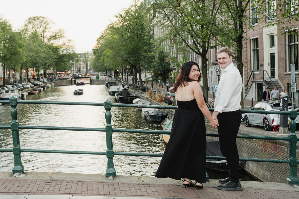 Newly engaged couple photographed beside an Amsterdam bridge