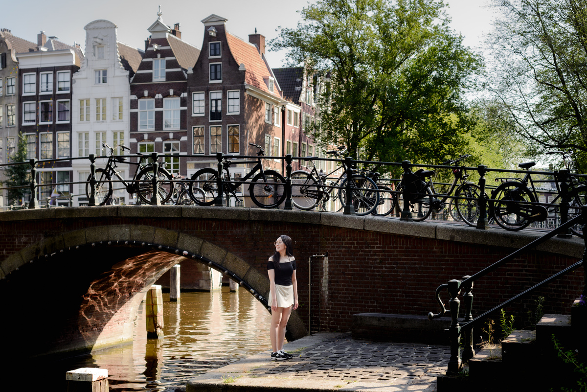 Solo traveller standing on a Leidsegracht bridge during an Amsterdam photo session