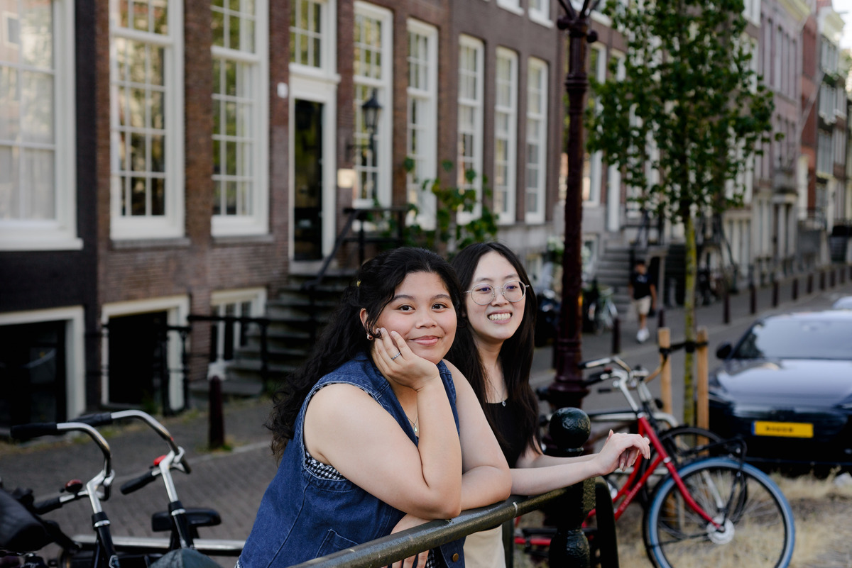 Friends laughing beside Leidsegracht during their Amsterdam photo session