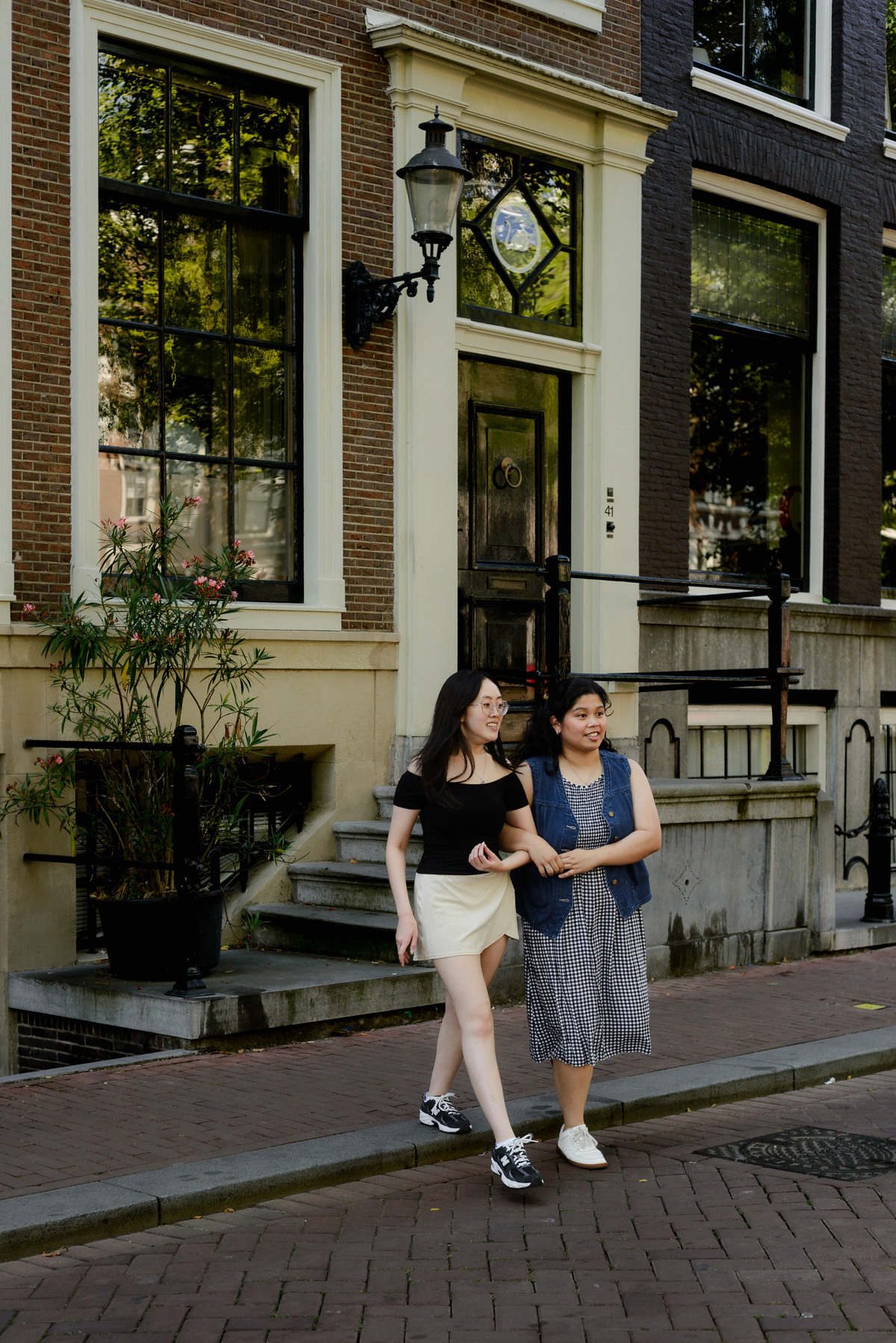 Two friends photographed together on an Amsterdam canal bridge