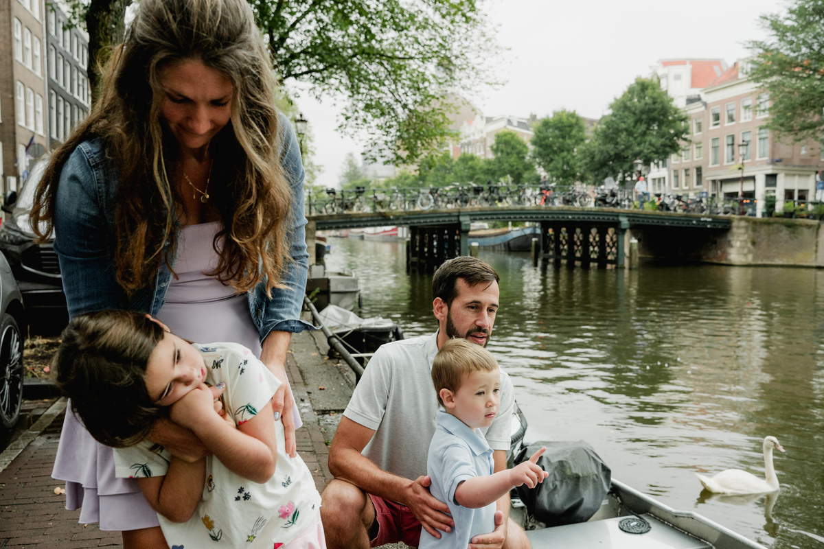 Parents sharing a playful moment with their children beside the canal.