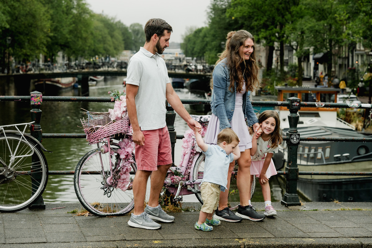Family gathering close together during a playful moment beside the canal.