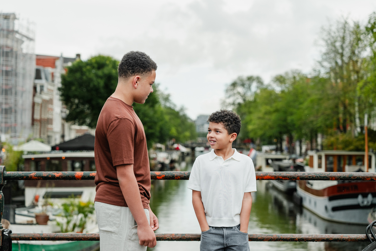 Two brothers posing and smiling together in the Jordaan, Amsterdam.