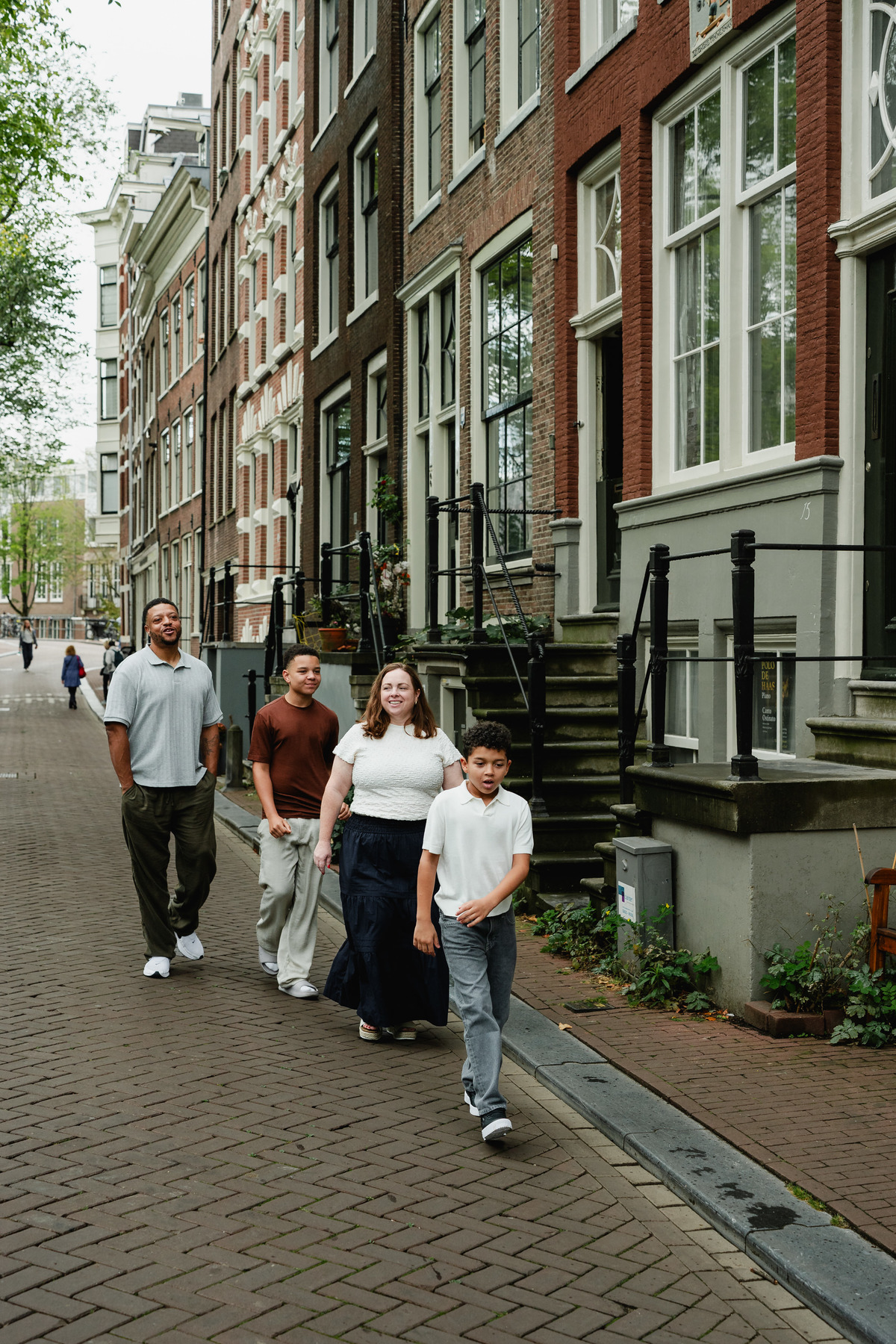 Family of four walking together through the streets of the Jordaan in Amsterdam.