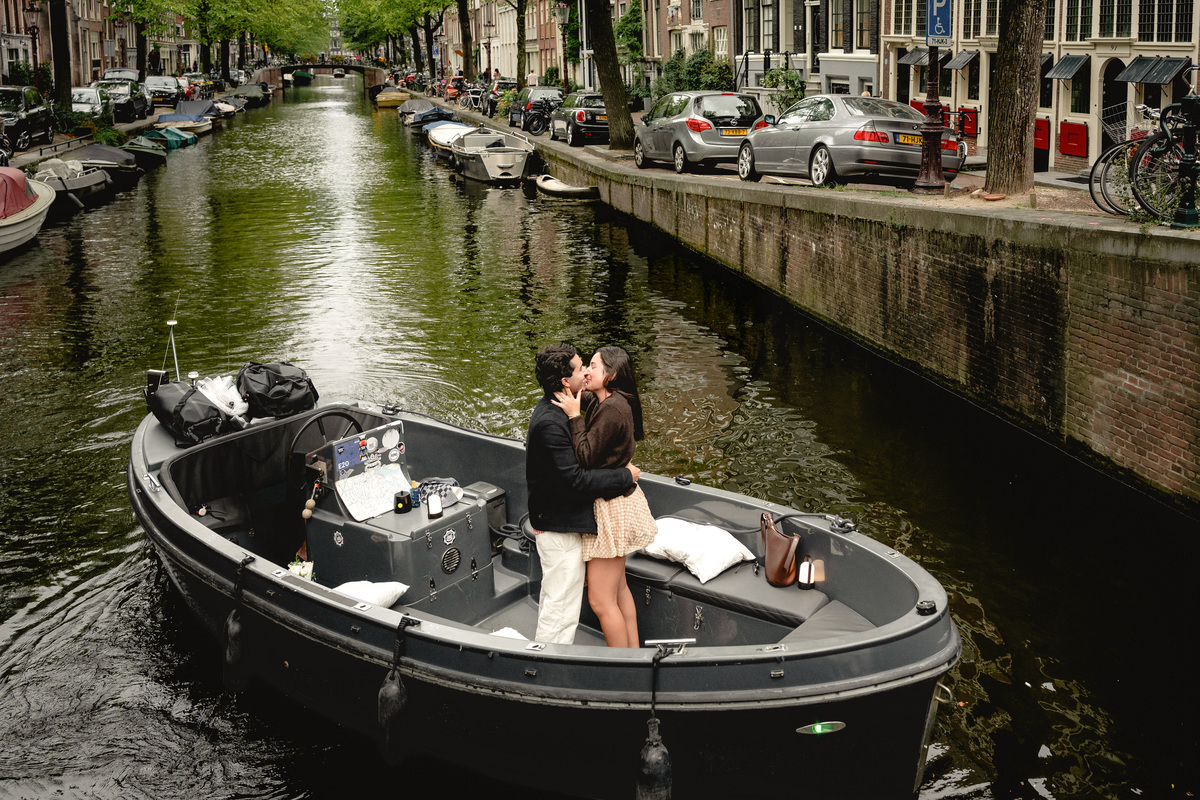 Open proposal boat surrounded by canal houses in Amsterdam.