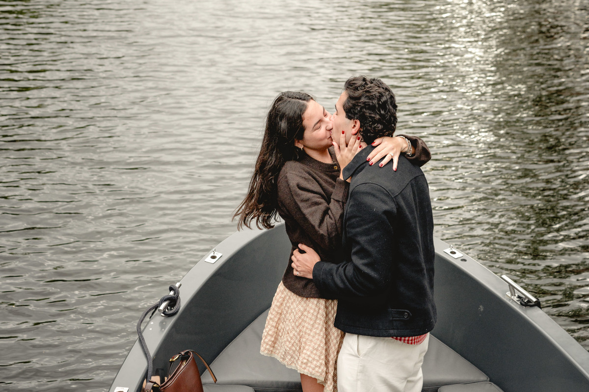 Newly engaged couple embracing on a private boat in Amsterdam.