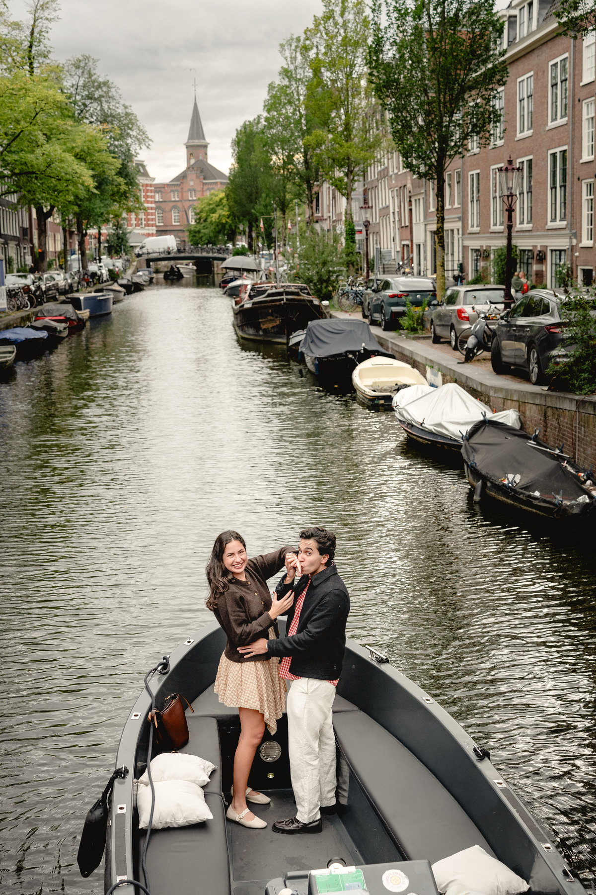 Couple celebrating after a surprise boat proposal on the canal.