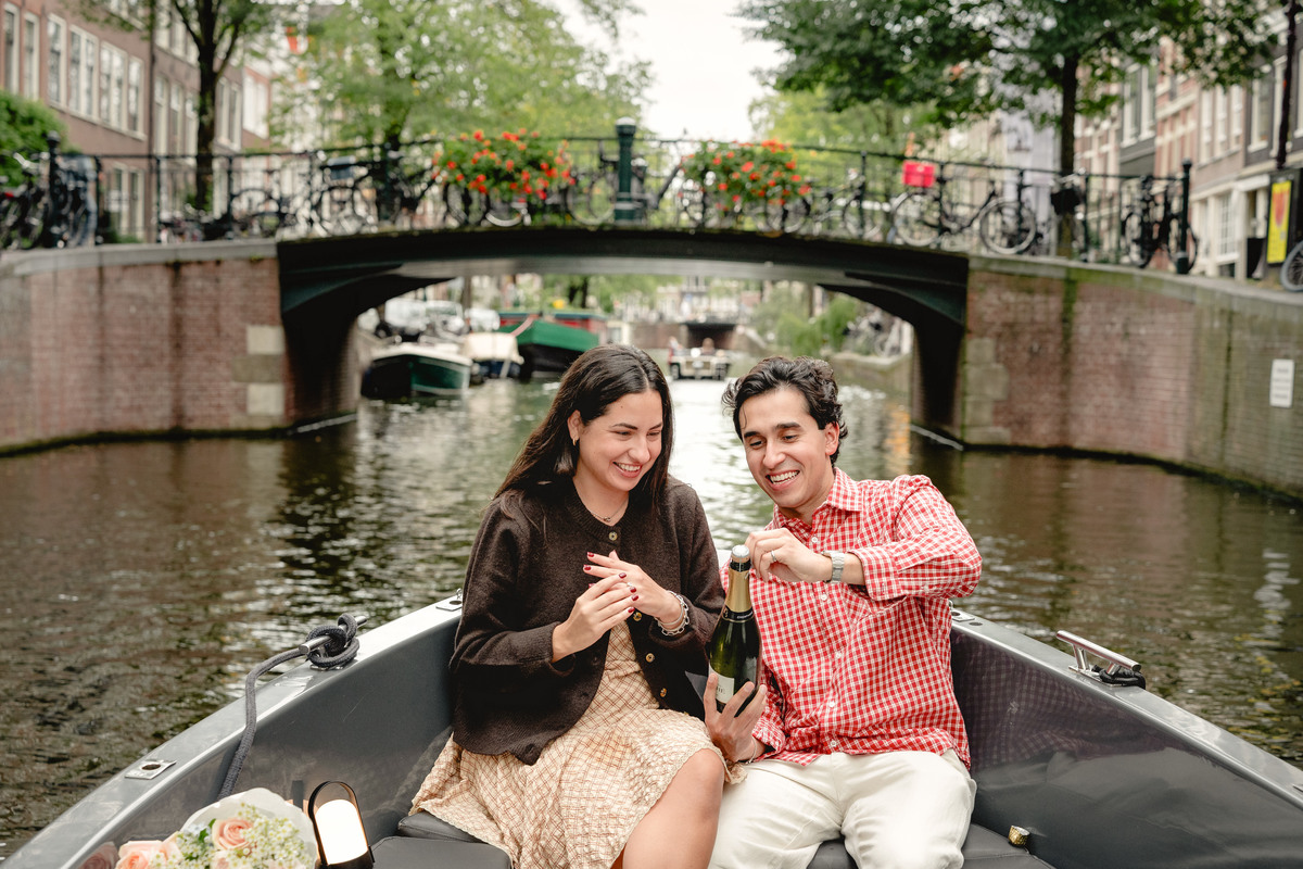 Couple enjoying champagne after their Amsterdam boat proposal.