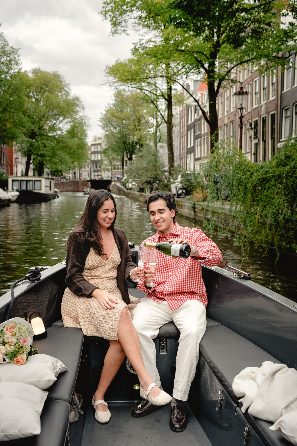 Newly engaged couple relaxing together on an Amsterdam canal boat.