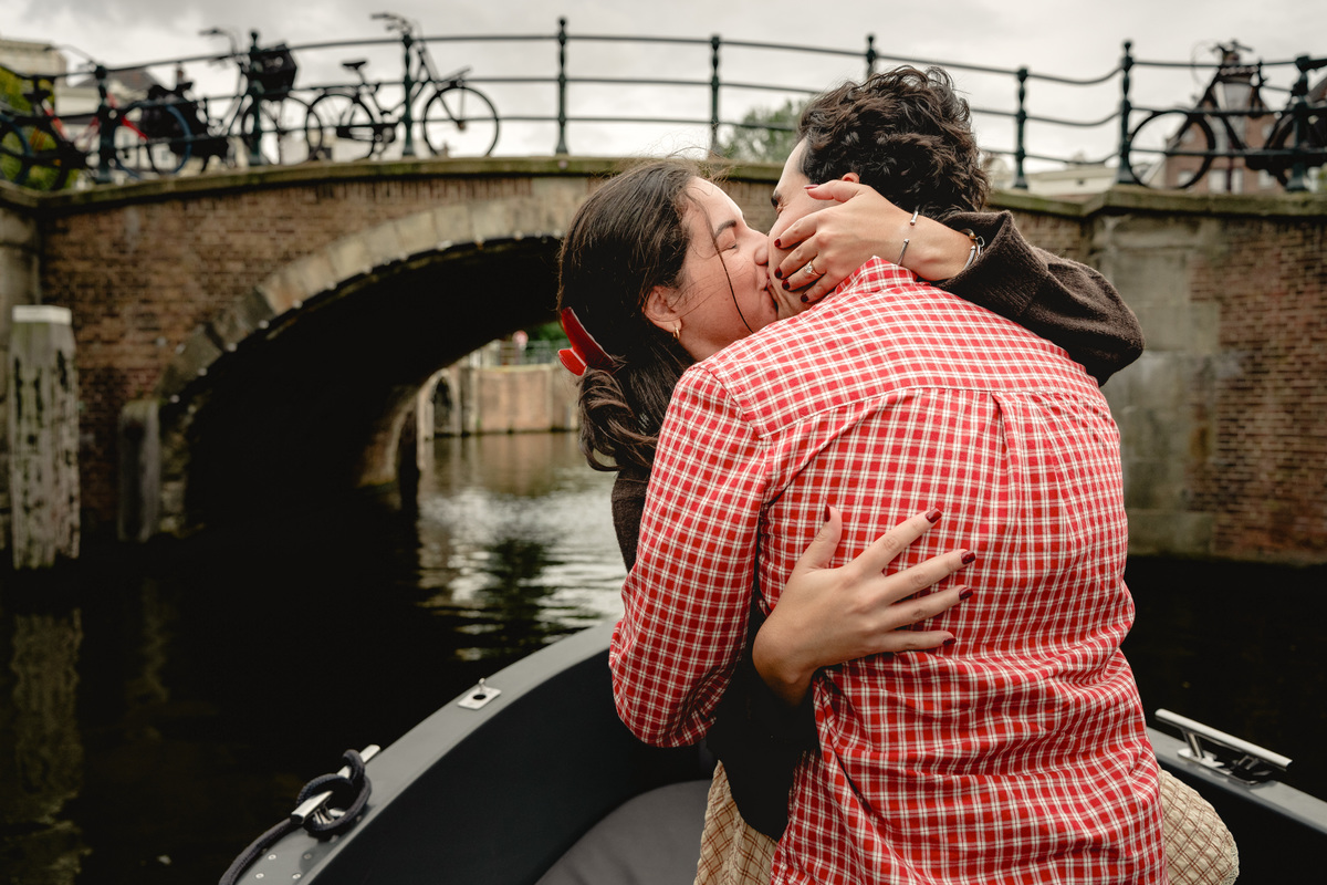 Engaged couple kissing during a private canal boat experience.

